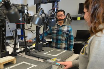 An image of biometrics students working with fingerprint scanning technology.
