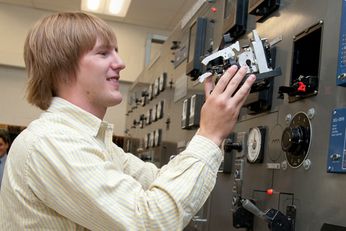 An image of a student working with an industrial circuit breaker